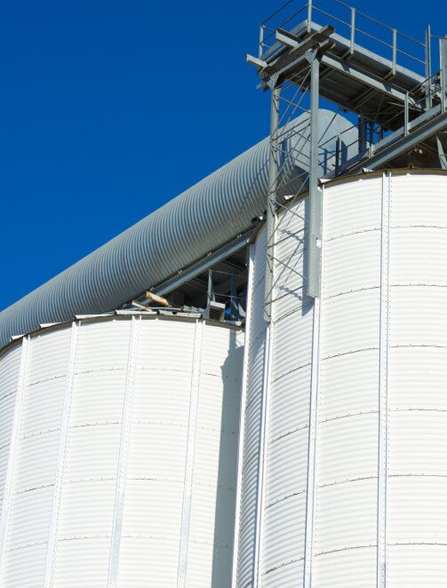 alt="Industriegebäude mit Tankschutzanlagen und blauer Himmel im Hintergrund"